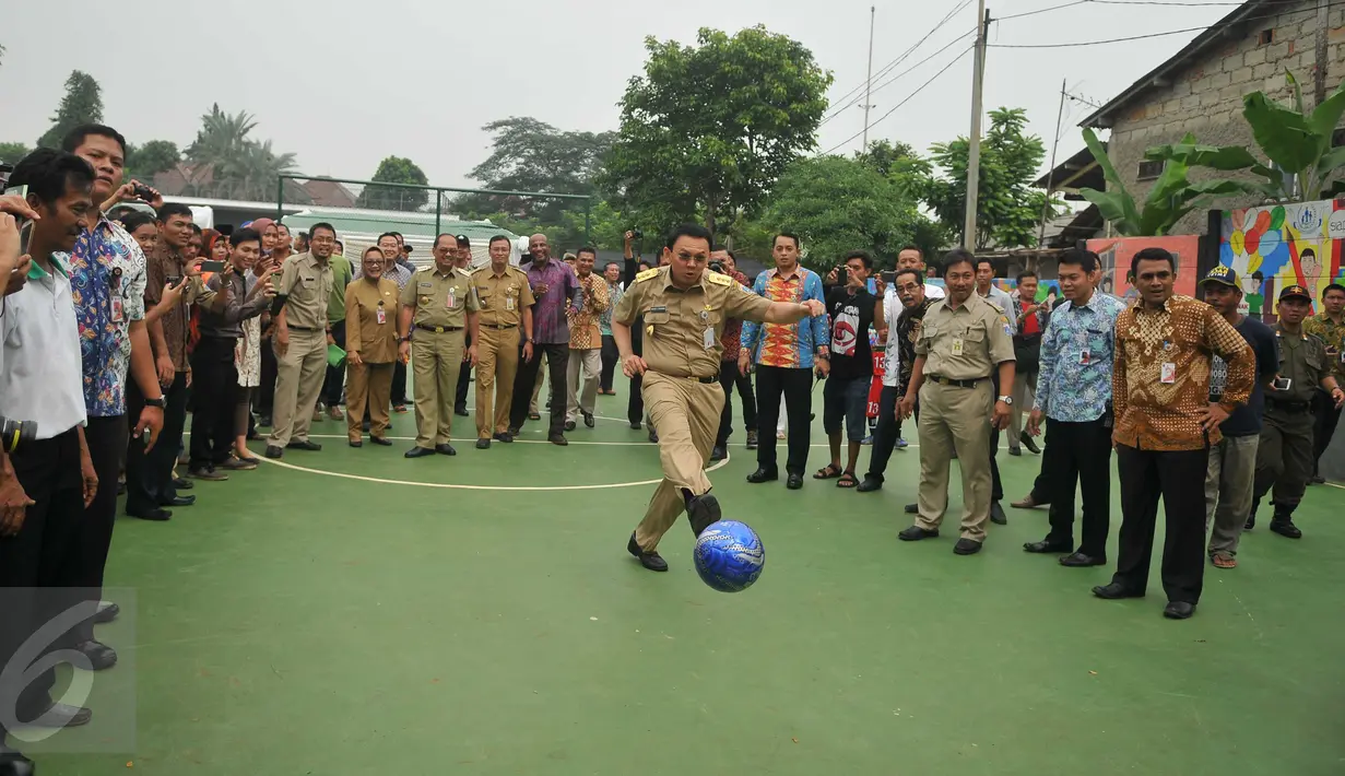 Gubernur DKI, Basuki 'Ahok' Tjahaja Purnama menendang bola usai meresmikan RPTRA Mawar di Kelurahan Lebak Bulus, Jakarta, (26/4). RPTRA tersebut guna memenuhi kebutuhan masyarakat akan ruang terbuka yang multi fungsi (Liputan6.com/Gempur M Surya)