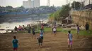Meski lapangan dadakan tersebut tidak rata dan berdebu, anak-anak terlihat tetap antusias bermain di bantaran KBB, Jakarta, Kamis (11/9/14). (Liputan6.com/Faizal Fanani)  