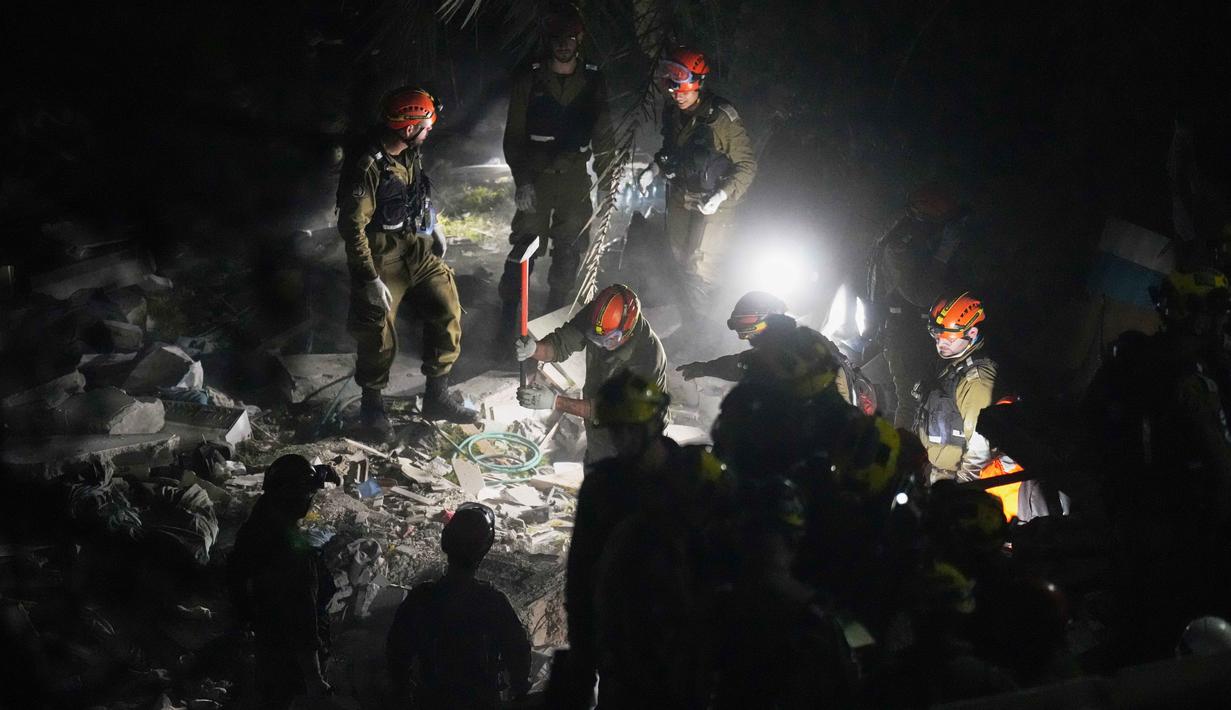 Untuk diketahui, serangan ini bagian dari eskalasi konflik besar di Timur Tengah yang melibatkan serangan rudal dan pesawat nirawak (drone) masif dari Iran ke berbagai titik di Israel, termasuk target infrastruktur seperti kilang minyak di Haifa. Tampak dalam foto, pasukan keamanan Israel dan tim penyelamat melakukan upaya pencarian korban di tengah reruntuhan bangunan tempat tinggal yang dihantam rudal Iran di Haifa, Israel, Minggu, 5 April 2026. (AP Photo/Ariel Schalit)