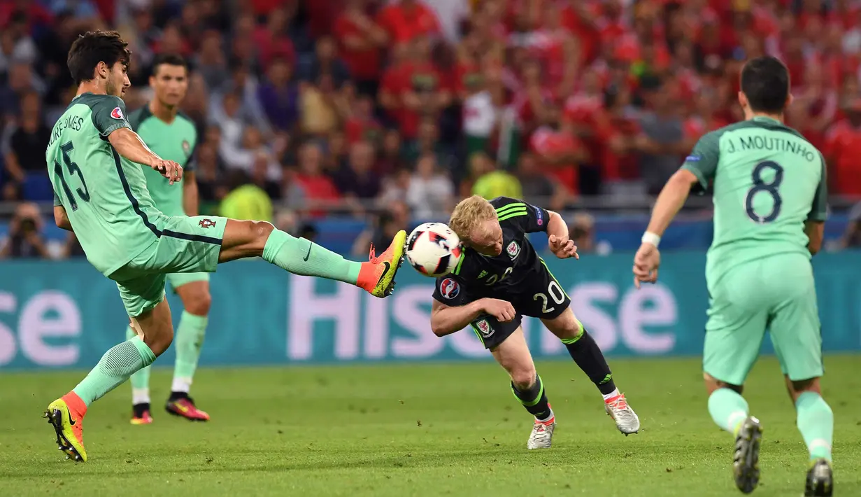 Pemain Wales, Jonathan Williams (tengah) menyundul bola dari sepakan pemain Portugal, Andre Gomes pada semi-final Piala Eropa 2016 di Stadion Parc Olympique Lyonnais, DÈcines-Charpieu, Prancis, Kamis (7/7/2016) dini hari WIB. (AFP/Francisco Leong)