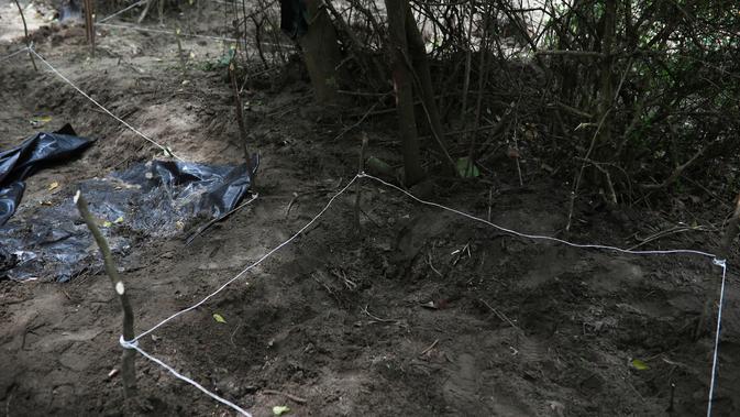 Pihak berwenang menutup area kuburan massal rahasia yang ditemukan di Arbolillo, negara bagian Veracruz, Meksiko, Jumat (7/9). Jaksa penuntut dari pengadilan Mekssiko menyebut penemuan tersebut berasal dari laporan seorang saksi. (AP/Felix Marquez)