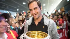 Petenis Swiss Roger Federer membawa trofi Australia Terbuka saat disambut penggemar di Bandara Zurich, di Kloten, Swiss, (30/1). Federer memenangkan final tunggal putramelawan petenis Kroasia Marin Cilic. (Ennio Leanza/Keystone via AP)