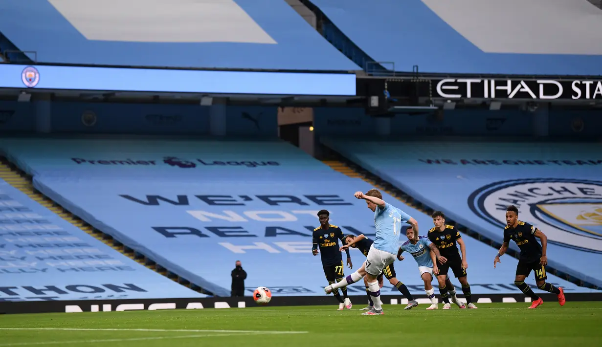 Pemain Manchester City Kevin De Bruyne mencetak gol ke gawang Arsenal lewat tendangan penalti pada laga Premier League di Etihad Stadium, Manchester, Inggris, Rabu (17/6/2020). Manchester City menang dengan skor 3-0. (LAURENCE GRIFFITHS/POOL/AFP)