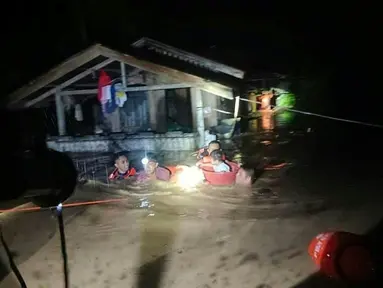 Penyelamat mengevakuasi orang-orang dari daerah banjir di Kota Ozamiz, Misamis Occidental, Filipina (25/12/2022). Dua orang tewas dan hampir 46.000 lainnya meninggalkan rumah mereka saat banjir pada libur Hari Natal. (Handout / Philippine Coast Guard (PCG) / AFP)
