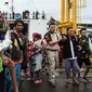 Petugas menggendong pengungsi usai turun dari kapal ferry di Pelabuhan Bakauheni, Lampung (26/12). Aktivitas gunung berapi anak Krakatau yang mengakibatkan gelombang tsunami 22 Desember lalu memaksa belasan ribu orang mengungsi. (AFP Photo/Mohd Rasfan)