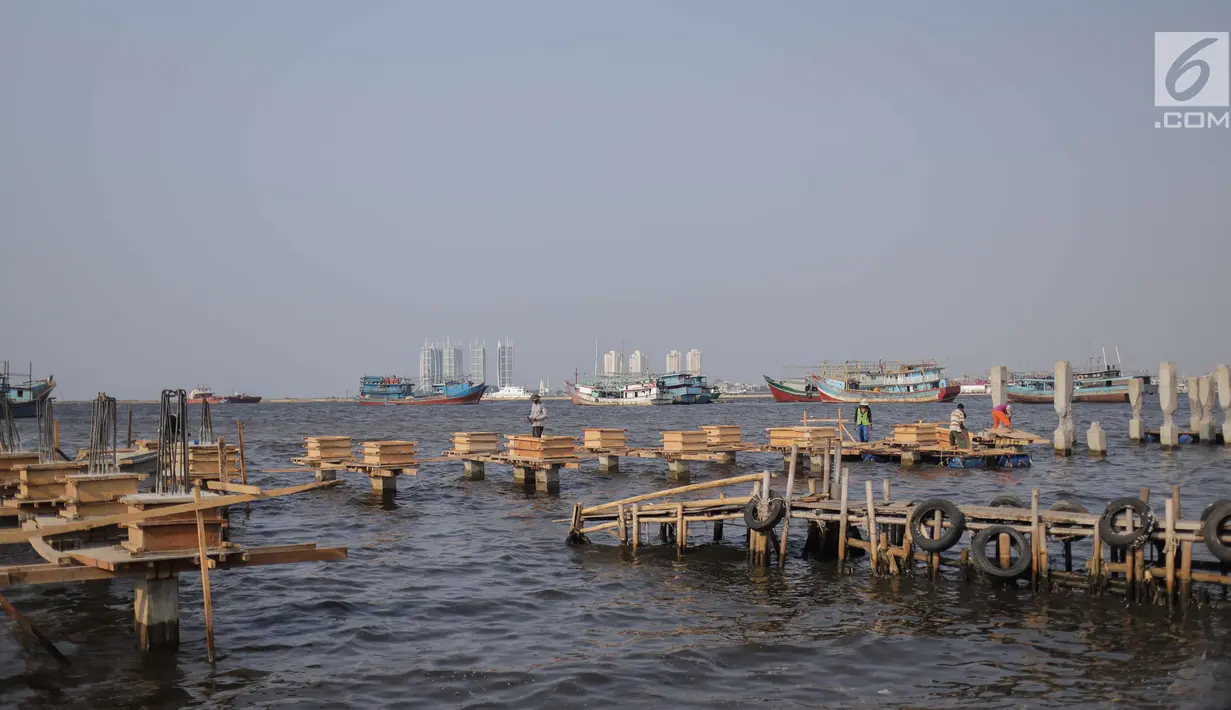 Pekerja menyelesaikan pondasi dermaga di Muara Angke, Jakarta Utara, Rabu (3/7/2019). Pembangunan dermaga tersebut untuk melindungi kapal-kapal yang bersandar di dermaga dari hantaman ombak besar. (Liputan6.com/Faizal Fanani)
