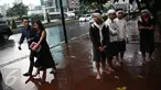 Empat warga Baduy berteduh ketika hujan mengguyur kawasan Bundaran HI, Jakarta, Selasa (6/9). Warga Baduy berjalan ratusan kilometer dari kampung mereka tanpa alas kaki dan sama sekali tidak menggunakan kendaraan bermotor. (Liputan6.com/Faizal Fanani)