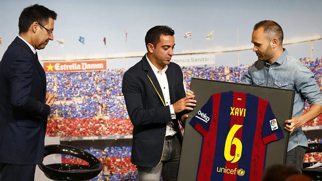 Xavi Hernandes (tengah) didampingi oleh Presiden Barcelona, Josep Maria Bartomeu (kiri) dan rekannya, Andres Iniesta (kanan) dalam konferensi pers perpisahannya, 3 Juni 2015. (EPA/ALEJANDRO GARCIA)