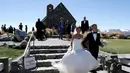 Sepasang suami istri meninggalkan Gereja setelah upacara pernikahan mereka di Danau Tekapo, Selandia Baru (6/10). Danau ini merupakan tujuan wisata yang populer dan terdapat beberapa hotel di kota kecil tersebut. (AP Photo/Mark Baker)