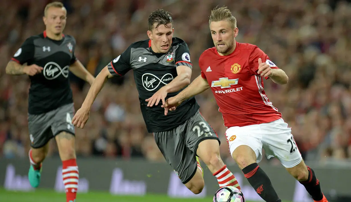 Bek Manchester United, Luke Shaw, berusaha melewati gelandang Southampton, Pierre-Emile Hojbjerg. Meski kalah penguasaan bola, namun serangan Setan Merah lbih efektif, tercacat ada tiga kali tembakan bola mengarah ke gawang. (AFP/Oli Scarff)