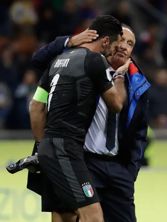 Pelatih Gian Piero Ventura menghibur kiper Italia, Gianluigi Buffon usai menjamu Swedia pada playoff zona Eropa di Stadion San Siro, Selasa (14/11). Buffon tak bisa menahan air matanya setelah timnya gagal lolos ke Piala Dunia 2018. (AP/Luca Bruno)