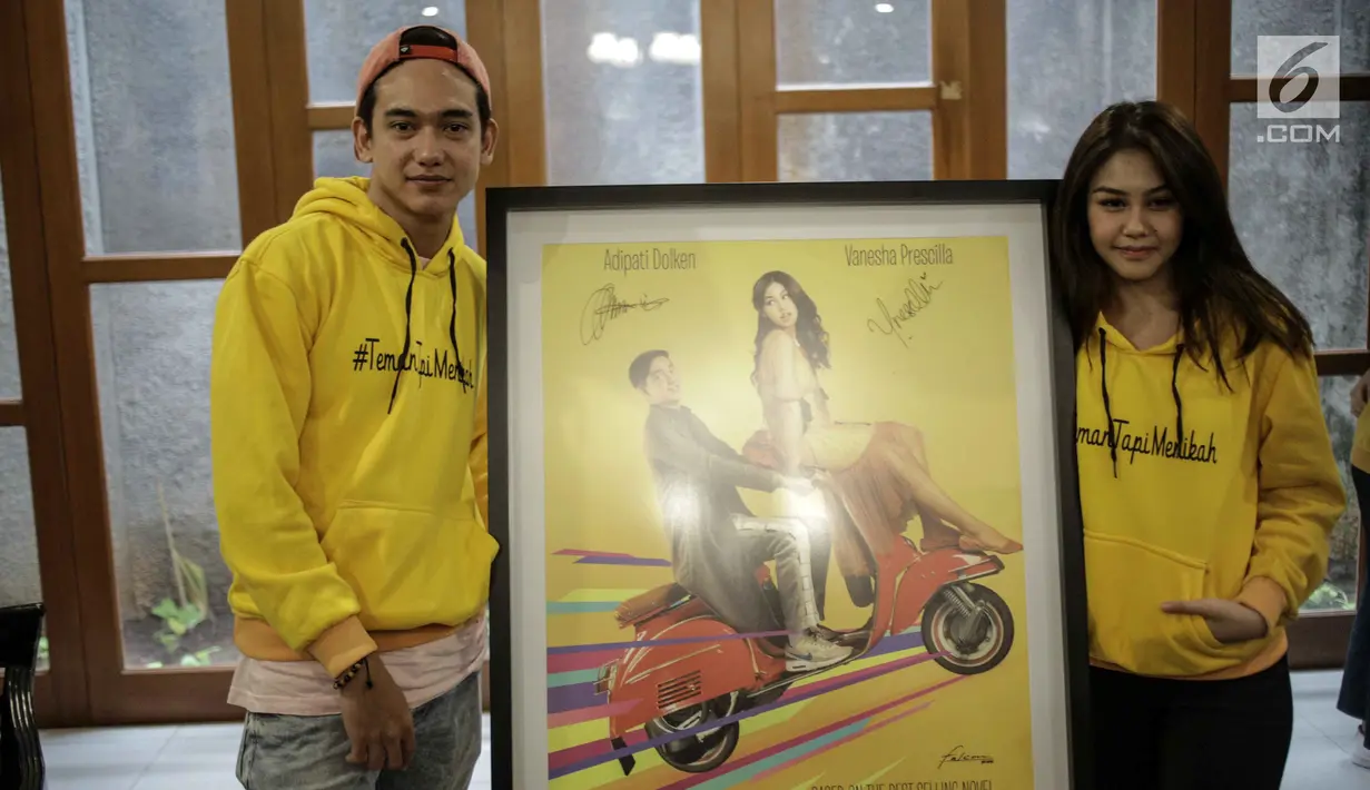 Adipati Dolken dan Vanesha Prescilla menunjukkan foto keduanya saat jumpa pers film Teman Tapi Menikah di Jakarta, Selasa (6/3). Dalam film ini, Adipati dan Vanesha saling cemburu saat keduanya memiliki pacar. (Liputan6.com/Faizal Fanani)