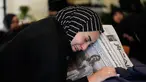 Zainab, saudara perempuan jurnalis Lebanon Amal Khalil yang tewas dalam serangan udara Israel pada Rabu 22 April 2026, memegang koran yang menampilkan potret saudara perempuannya, saat ia berduka di atas peti matinya di desa Baysariyeh, Lebanon Selatan, Kamis 23 April 2026. Jurnalis surat kabar Al-Akhbar, Amal Khalil, ditemukan meninggal dunia imbas serangan udara Israel di Kota al-Tayri, Lebanon Selatan pada Rabu 22 April 2026. (AP Photo/Mohammed Zaatari)