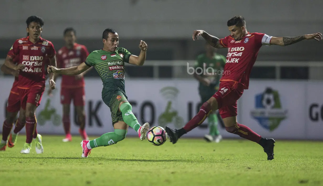 Bek Arema FC, Arthur Cunha, berebut bola dengan gelandang PS TNI, Guntur Triaji, pada laga Liga 1 di Stadion Pakansari, Bogor, Senin (3/7/2017). Kedua klub bermain imbang 0-0. (Bola.com/Vitalis Yogi Trisna)