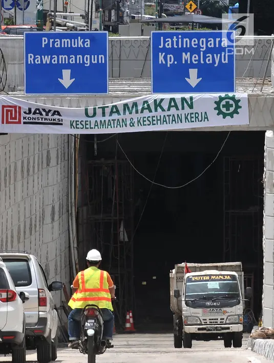 Pekerja menggunakan sepeda motor saat lalu lalang masuk ke proyek Underpass Matraman, Jakarta, Minggu (1/4). Underpass ini dibangun dengan panjang 650 meter dan lebar jalan 7 meter. (Merdeka.com/Iqbal S Nugroho)