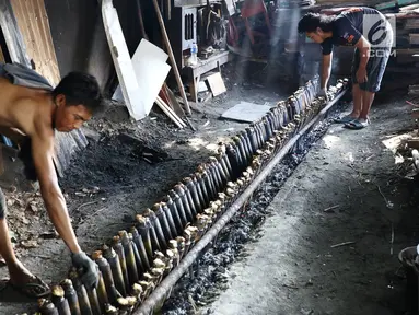 Pekerja menyelesaikan pembuatan makanan lemang di kawasan Senen, Jakarta, Selasa (30/5). Lemang adalah makanan khas tradisional yang populer di tanah Melayu. (Liputan6.com/Immanuel Antonius)