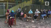 Sejumlah warga menunggu untuk divaksin di MTs As-Syafiiyah, Cilangkap, Jakarta, Kamis (3/6/2021).  Vaksinasi massal bagi warga RT 03/RW 03 Cilangkap, Cipayung, Jakarta Timur menggunakan vaksin produksi AstraZeneca. (Liputan6.com/Herman Zakharia)