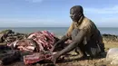 Nelayan memotong daging hiu hasil tangkapan di Pantai Mballing, Dakar, Senegal (1/4/2016). Daging hiu biasanya dikonsumsi, dijual di pasar lokal, hingga diekspor ke negara tetangga. (AFP Photo/Seyllou)