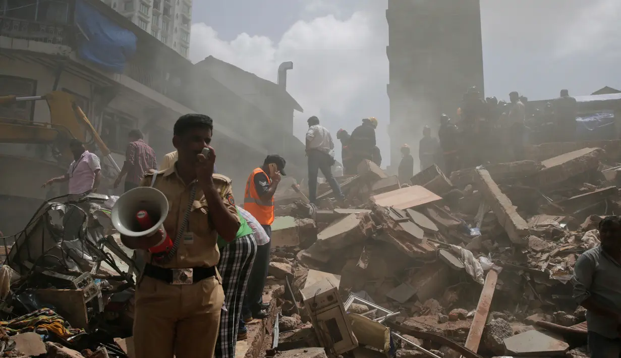Petugas keamanan dan penyelamat mencari korban yang tertimbun puing reruntuhan bangunan di Mumbai, India (31/8). (AP Photo / Rafiq Maqbool)