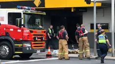Petugas layanan darurat terlihat di lokasi kebakaran yang terjadi di kantor cabang Commonwealth Bank of Australia, di Melbourne , Jumat (18/11). Kejadian ini menyebabkan 27 orang terluka dan enam lainnya dinyatakan kritis. (AAP/Julian Smith/via REUTERS) 