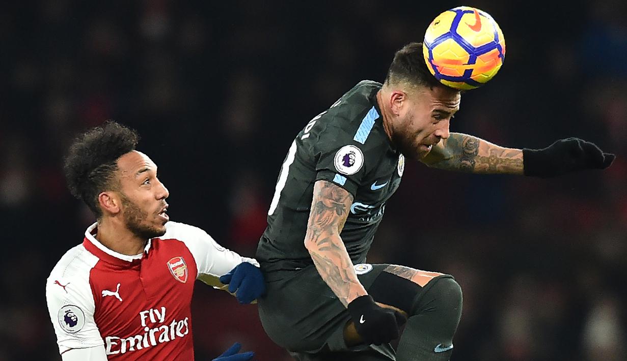 Bek Manchester City, Nicolas Otamendi, membuang bola dari striker Arsenal, Pierre-Emerick Aubameyang, pada laga Premier League di Stadion Emirates, London, Kamis (1/3/2018). Arsenal kalah 0-3 dari City. (AFP/Glyn Kirk)