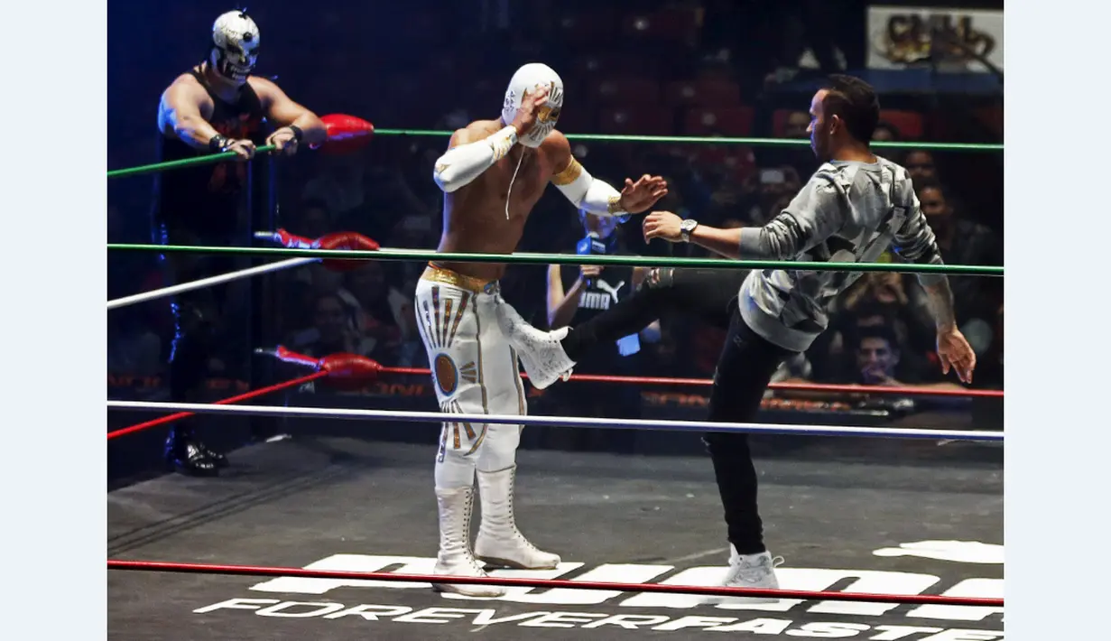 Lewis Hamilton berusaha menendang pegulat yang bintang WWE di Coliseo Arena, Mexico City, (28/10/2015). (Reuters/Henry Romero)