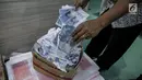 Petugas Direktorat Tindak Pidana Ekonomi Khusus Bareskrim Polri memperlihatkan uang palsu saat rilis di Bareskrim Polri, Jakarta, Jumat (16/6). Dalam penangkapan polisi mengamankan 1.000 lembar uang pecahan Rp 50.000 palsu. (Liputan6.com/Faizal Fanani)
