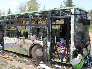 Kondisi bus yang membawa pengungsi Suriah usai terkena serangan bom di Rasyidin, Aleppo, Suriah, Minggu (16/4). Serangan bom tersebut diperkirakan telah menewaskan 126 orang. (AFP Photo/Omar Haj Kadour)