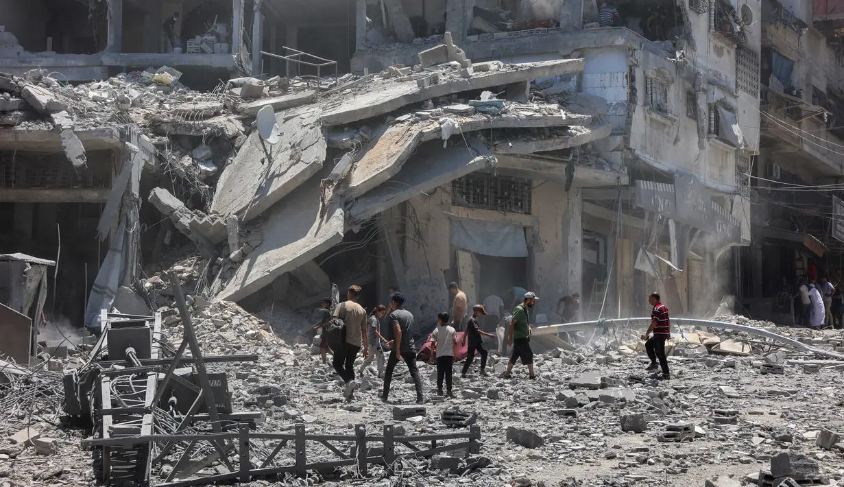 Warga Palestina mencari barang-barang yang dapat diselamatkan di reruntuhan bangunan yang hancur sehari sebelumnya dalam serangan Israel di lingkungan Al-Daraj, Kota Gaza pada 16 Juli 2025. (Omar AL-QATTAA/AFP)