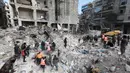 Tim penyelamat Suriah mencari korban dan penyintas yang terjebak di bawah reruntuhan bangunan yang runtuh di Aleppo, Selasa 7 Februari 2023, setelah gempa bumi mematikan yang melanda wilayah tersebut pada hari sebelumnya. Gempa berkekuatan 7,8 SR tersebut terjadi di dekat kota Gaziantep, Turki, menewaskan lebih dari 2.300 orang di Turki dan lebih dari 1.400 orang di negara tetangganya, Suriah. (LOUAI BESHARA/AFP)