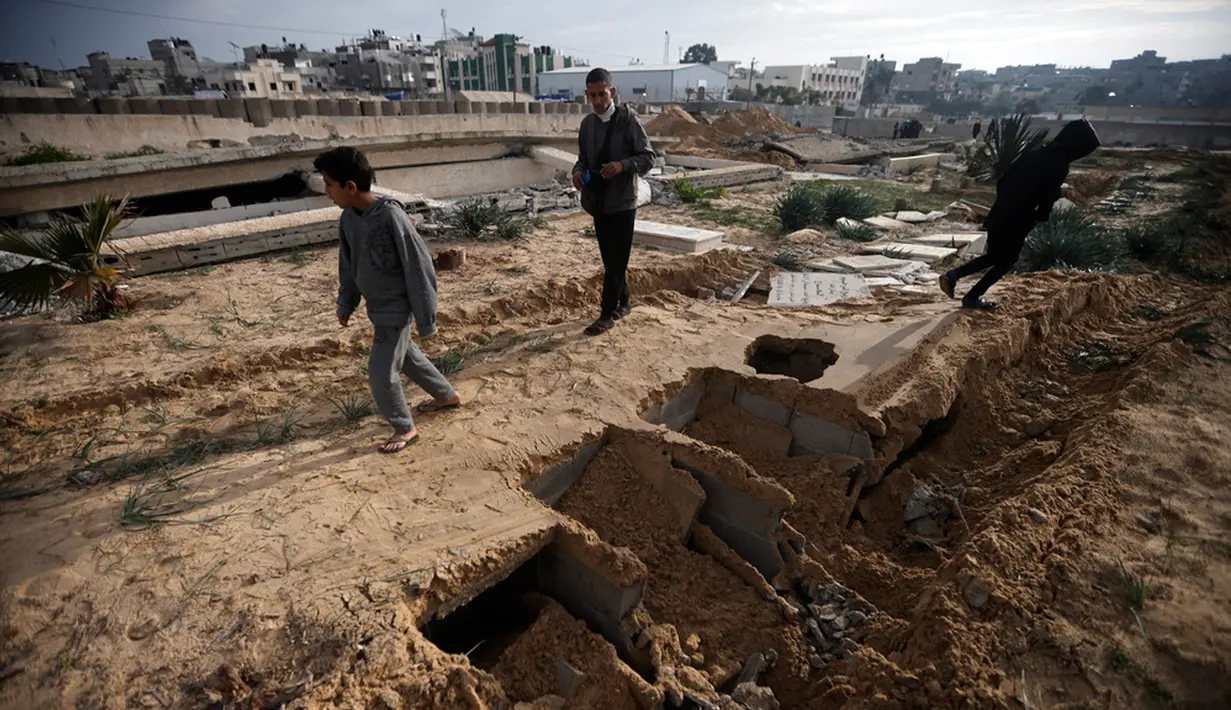 Batu nisan yang rusak berserakan di tanah. Kuburan pun berubah jadi terlihat seperti jalan kendaraan militer Israel. (AP Photo/Mohammed Dahman)