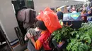 Peserta mudik gratis bareng PDIP menaiki kereta api di Stasiun Pasar Senen, Jakarta, Selasa (12/6). PDIP memberangkatkan 725 pemudik dengan kereta api pada hari ini. (Liputan6.com/Angga Yuniar)