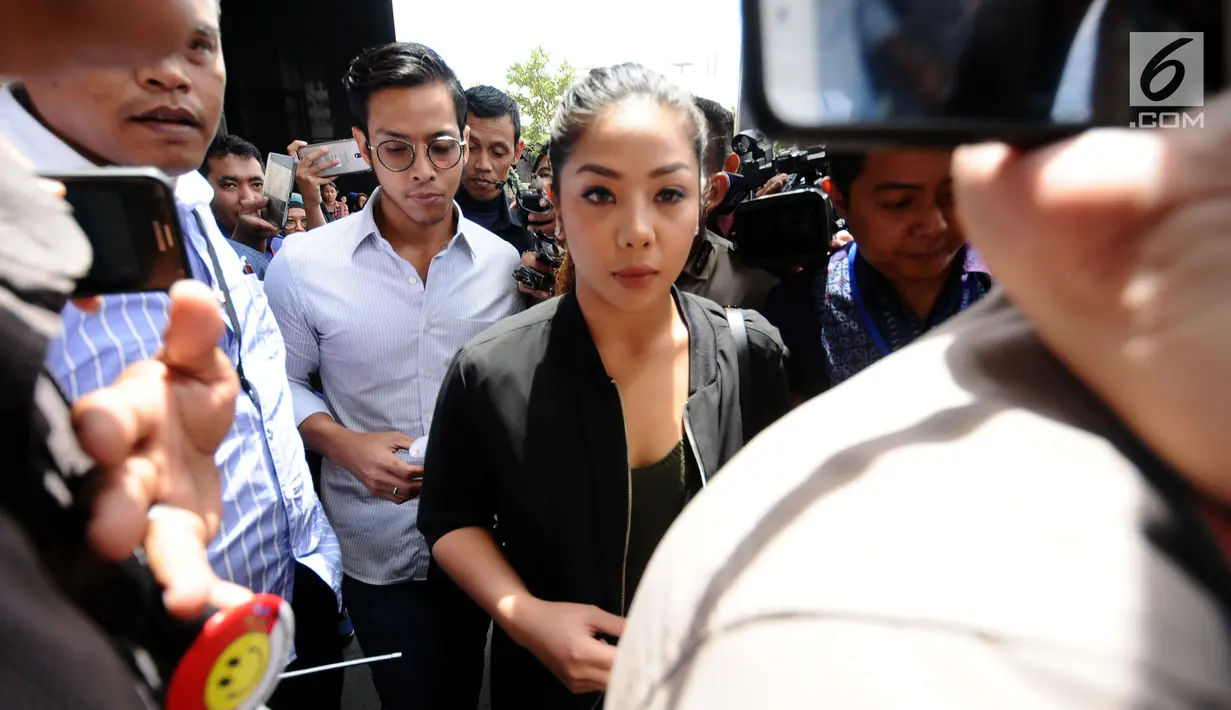 Anak tersangka dugaan korupsi e-KTP Setya Novanto, Dwina Michaella (depan) bersama Rheza Herwindo meninggalkan gedung KPK usai diperiksa, Jakarta, Rabu (10/1). Keduanya diperiksa untuk tersangka Anang Sugiana Sudihardjo. (Liputan6.com/Helmi Fithriansyah)