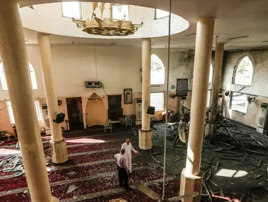 Dua pria memeriksa kerusakan masjid yang terkena serangan udara Israel di Kota Gaza, Palestina (15/7). Militer Israel mengatakan telah meluncurkan serangan udara yang menargetkan pasukan Hamas di Jalur Gaza, Sabtu (14/7) lalu. (AFP  Photo/Mahmud Hams)