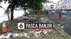 Material batu dan sampah berserakan di sepanjang jalan kawasan Megamas, Manado, pasca diterjang banjir rob pada Minggu (17/1) sore kemarin.