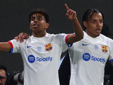 Pemain Barcelona, Lamine Yamal (kiri) melakukan selebrasi setelah mencetak gol kemenangan timnya ke gawang Osasuna pada babak semifinal Piala Super Spanyol di Stadion Al-Awwal, Riyadh, Arab Saudi, Kamis (11/01/2024). (AFP/Fayez Nureldine)