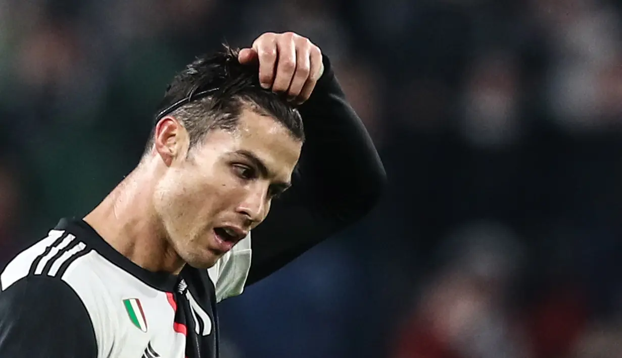Penyerang Juventus, Cristiano Ronaldo, melepas ikat rambutnya pada matchday kelima Grup D Liga Champions menghadapi Atletico Madrid di Allianz-Stadium, Turin, Selasa (26/11/2019). Aksesoris itu terlihat janggal sebab Ronaldo tidak pernah menggunakan ikat kepala saat bermain. (Isabella BONOTTO / AFP)