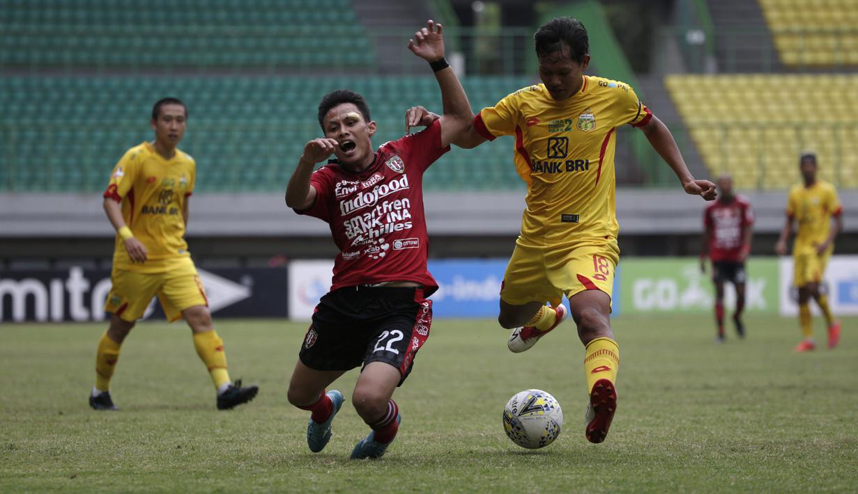 Gelandang Bhayangkara FC, Adam Alis, berebut bola dengan bek Bali United, Dias Angga, pada laga Shopee Liga 1 di Stadion Patriot Chandrabhaga, Bekasi, Jumat (13/9). Bhayangkara bermain imbang 0-0 atas Bali United. (Bola.com/Yoppy Renato)