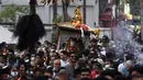 Orang-orang mengambil bagian dalam prosesi ketika para imam membawa Seto Machindranath, dewa pelindung Nepal, selama festival kereta di Kathmandu (9/4/2022). (AFP/Prakash Mathema)