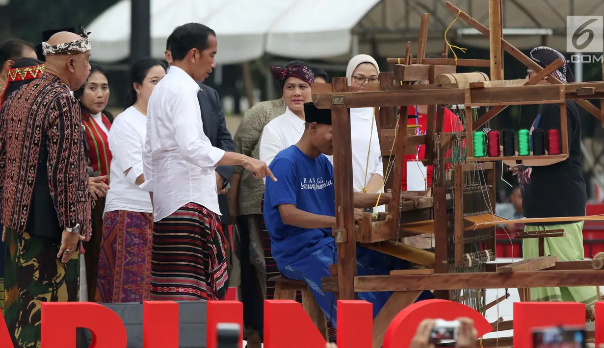 Presiden Joko Widodo melihat proses penenunan kain di Festival Sarung Indonesia 2019, Plaza Tenggara Kompleks GBK, Jakarta, Minggu (3/3). Festival ini untuk menghidupkan kesadaran generasi muda akan kekayaan budaya. (Liputan6.com/Helmi Fithriansyah)