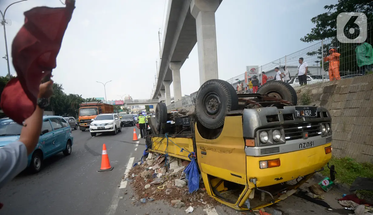 Truk bermuatan puing terbalik akibat salah satu ban belakang lepas di jalan tol Pondok Indah dekat pintu keluar Lebak Bulus, Jakarta, Jumat (29/5/2020). Dalam kecelakaan tersebut tidak ada korban jiwa namun membuat kendaraan yang melintas jalan tol tersendat. (merdeka.com/Dwi Narwoko)