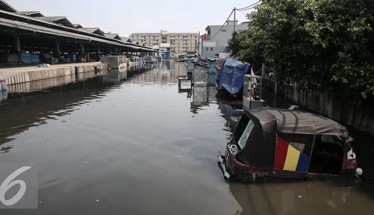 Kendaraan terendam banjir rob di pasar ikan Pelabuhan Muara Baru, Penjaringan, Jakarta, (7/6). Banjir rob terjadi akibat jebolnya tanggul di sisi Timur Pelabuhan Muara Baru hingga meluapnya air yang mencapai sekitar 50 cm. (Liputan6.com/Faizal Fanani)