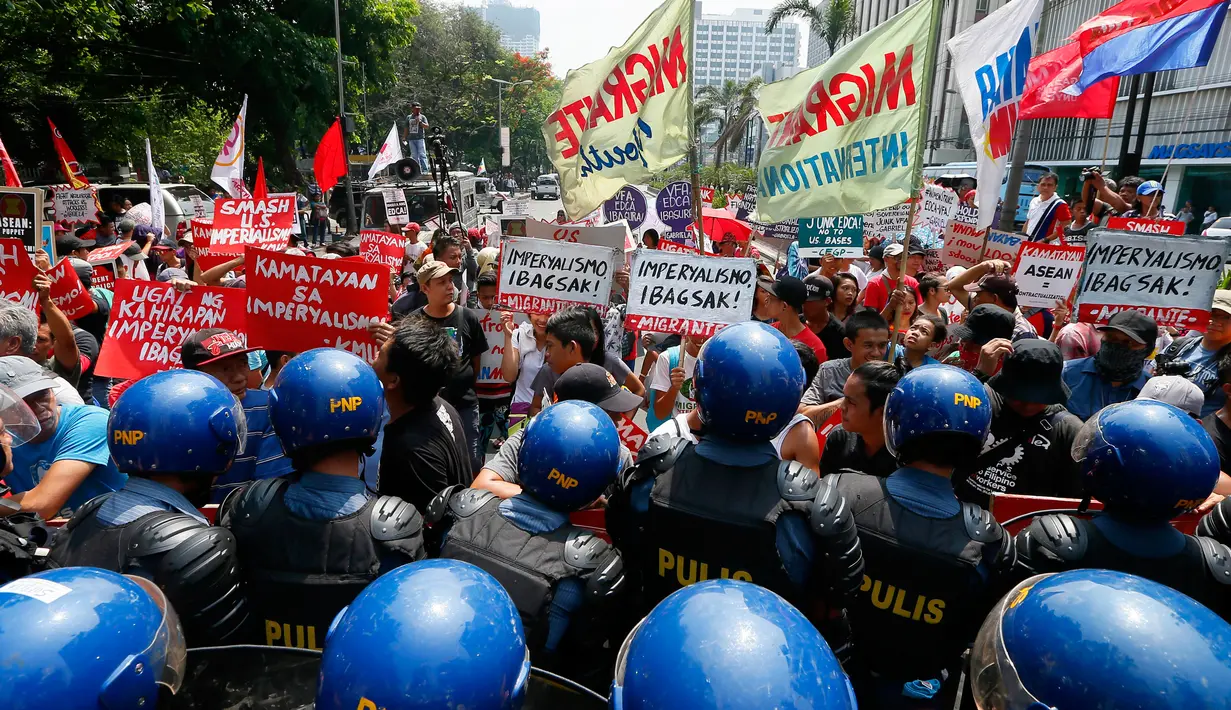 Sejumlah orang menggelar aksi protes di depan Kedutaan Besar AS di Manila, Jumat (28/4). Demonstran memprotes dugaan penguasaan oleh Amerika Serikat, Jepang dan China atas Asia Tenggara. (AP Photo / Bullit Marquez)