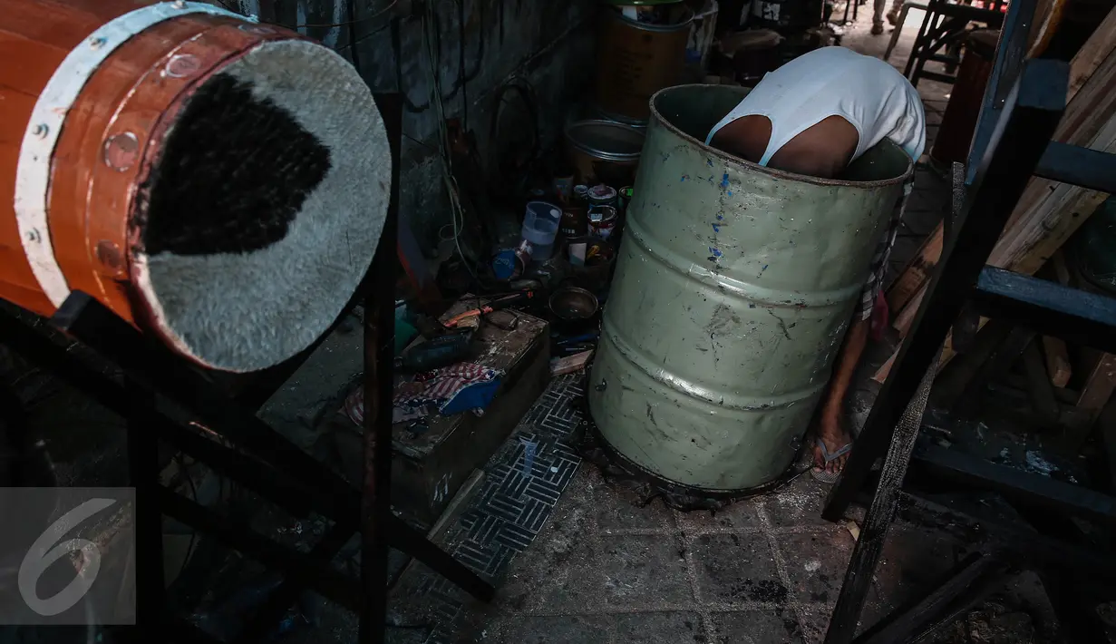 Ridho (52) memasang pengikat ke dalam drum di kawasan Tanah Abang, Jakarta, Jumat (17/6). Aneka ragam bedug yang dijual dari harga Rp.100 ribu hingga Rp 4 juta. (Liputan6.com/Faizal Fanani)