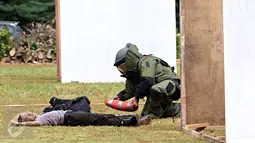 Seorang anggota Gegana dan Jibom memeriksa sebuah bungkusan mencurigakan di lokasi ledakan saat simulasi penanggulangan bom di lapangan Direktorat Sabhara Polda Metro Jaya, Kamis (4/2). (Liputan6.com/Immanuel Antonius)