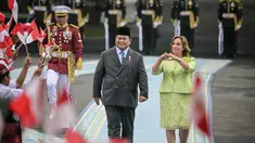 Presiden Republik Indonesia Prabowo Subianto (kiri) bersam Presiden Peru Dina Boluarte menyaksikan anak-anak mengibarkan bendera kedua negara sebelum pertemuan mereka di Istana Merdeka, Jakarta, pada 11 Agustus 2025. (Bay ISMOYO/AFP)
