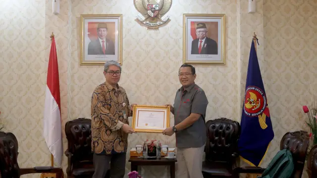 Wakil Direktur Utama IFG Haru Koesmahargyo (kanan) menerima Sertifikasi Program Kepatuhan Persaingan Usaha yang diberikan oleh Deputi Bidang Kajian dan Advokasi KPPU Taufik Ariyanto (kiri) di Jakarta, pada Kamis (22/08/24).  (Dok IFG)