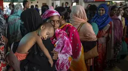 Seorang wanita menggendong anaknya saat mengantre membeli tiket menjelang Hari Raya Idul Adha 1440 H di sebuah stasiun kereta api di Dhaka (2/8/2019). Di Indonesia Idul Adha jatuh pada Minggu, 11 Agustus mendatang. (AFP Photo/Munir Uz Zaman)