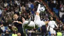 Pemain Real Madrid, Cristiano Ronaldo (kanan) melakukan tendangan salto melewaati pemain Malmo FF, Anton Tinnerholm  pada lanjutan Liga Champions Grup A di Stadion Satiago Bernabeu, Rabu (9/12/2015) dini hari WIB. (AFP Photo/ Pierre-Philippe Marcou)
