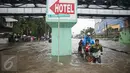 Warga menaiki gerobak untuk menyeberangi banjir yang merendam Jalan Gunung Sahari, Jakarta Pusat, Selasa (21/2). Hujan yang turun sejak dini hari menyebabkan sejumlah ruas jalan terimbas banjir dan tak bisa dilalui kendaraan. (Liputan6.com/Faizal Fanani)